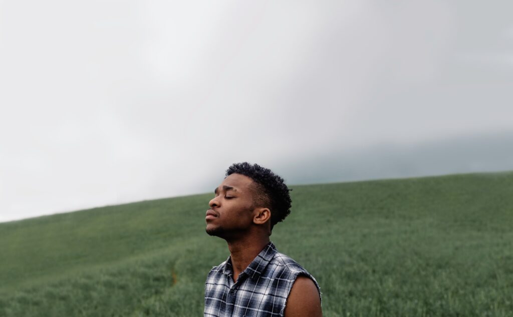 man wearing black, gray, and white plaid sleeveless top