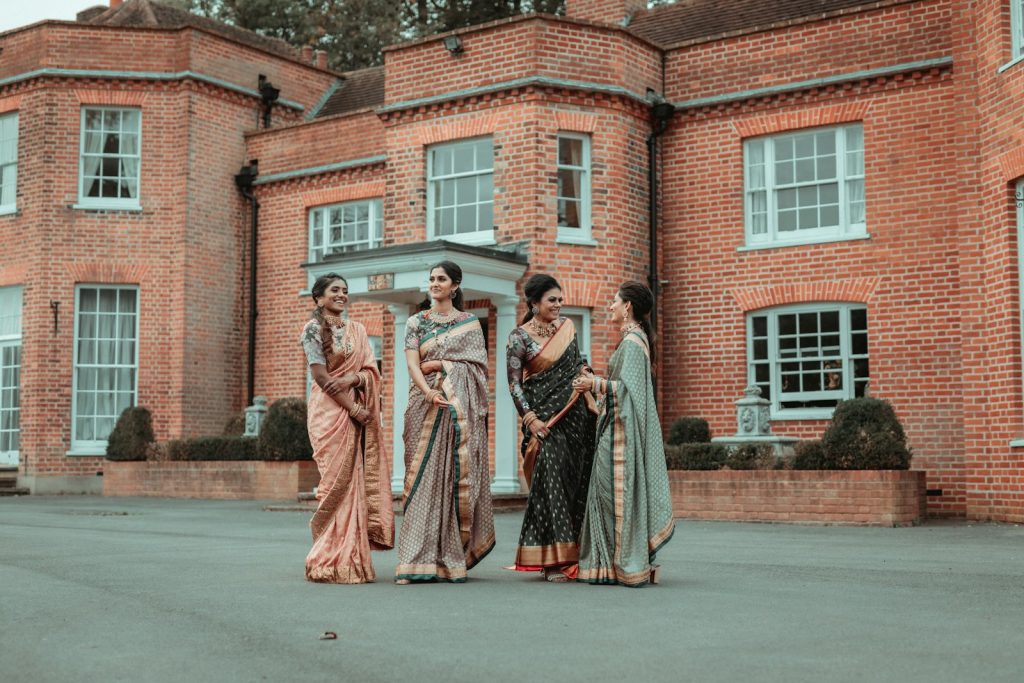 3 women in brown dress standing on gray concrete floor during daytime