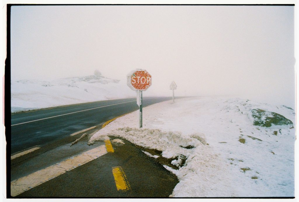 A stop sign on a snowy mountain road